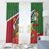 Green window curtains with bird and palm-figure print, with sheer inner curtain visible