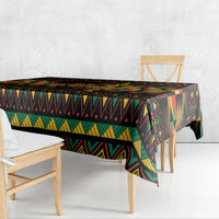 Kwanzaa festival tablecloth with bold geometric stripes, draped over table corner, black base.