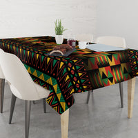 Kwanzaa festival tablecloth, black with multicolor geometric pattern, neatly spread on dining table.