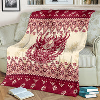 Red and cream Christmas blanket featuring a red Krampus face amid Nordic diamond patterns