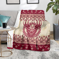 Red and cream Christmas blanket with Krampus head center and repeating Nordic symbols