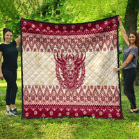 Large red and cream quilt with centered Krampus face and festive diamond border pattern.