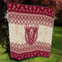 Red and cream quilt showing centered Krampus face over quilted diamond holiday pattern.