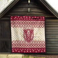 Red and cream quilt hung outdoors with Krampus face centerpiece and diamond Nordic trim.