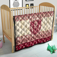 Red and cream quilt on toddler bed, quilted diamonds and Krampus face centerpiece design.