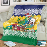 Folded out Christmas blanket with parrot illustration, Santa hat, and blue-yellow-green chevrons