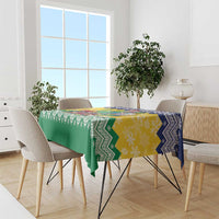 Green and yellow Christmas tablecloth with blue zigzag border across dining table