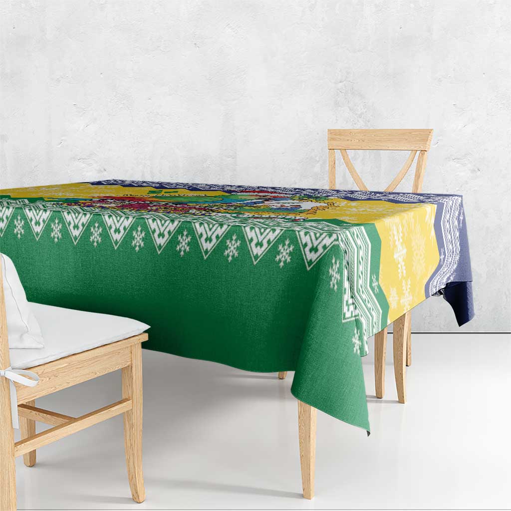 Green and yellow patterned Christmas tablecloth with blue trim, draped over dining bench
