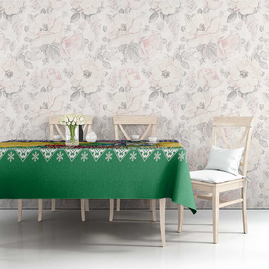 Green Christmas tablecloth with patterned border across dining table and matching chairs