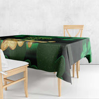Green and black patterned tablecloth with shamrocks and coin motifs on table edge