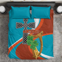 Bedding set with teal and rust duvet cover featuring cross and harp graphic, plus two teal pillows