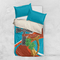 Bedding set with teal pillows and teal-rust duvet cover, cross and harp artwork on top