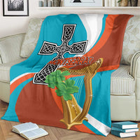 Teal and rust throw blanket with white stripes, cross-harp crest, and clover