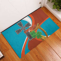 Teal and brown rubber doormat with black cross emblem and gold harp