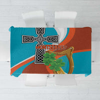 Teal and rust tablecloth with gold harp and black cross motif, square view