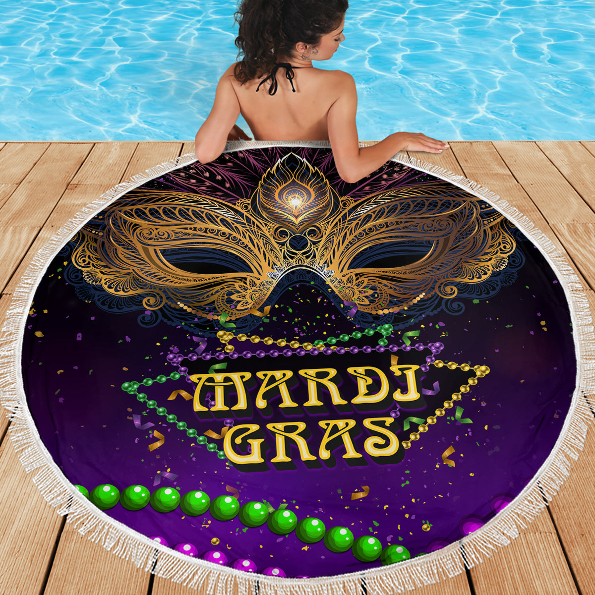 Purple round beach blanket with gold mask design and Mardi Gras lettering, tassel fringe edge