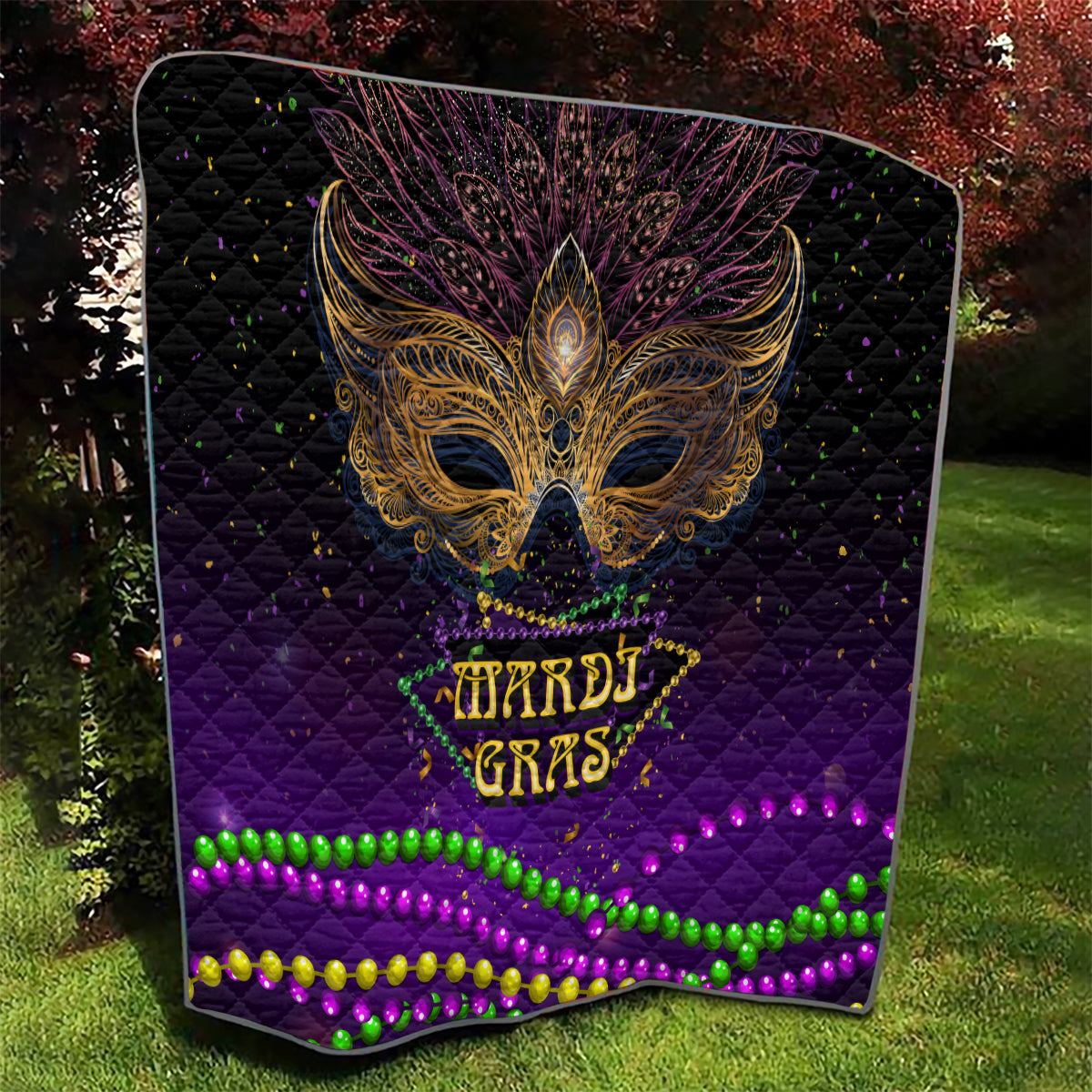 Purple Mardi Gras quilt with gold feathered bird mask and glowing bead stripe accents