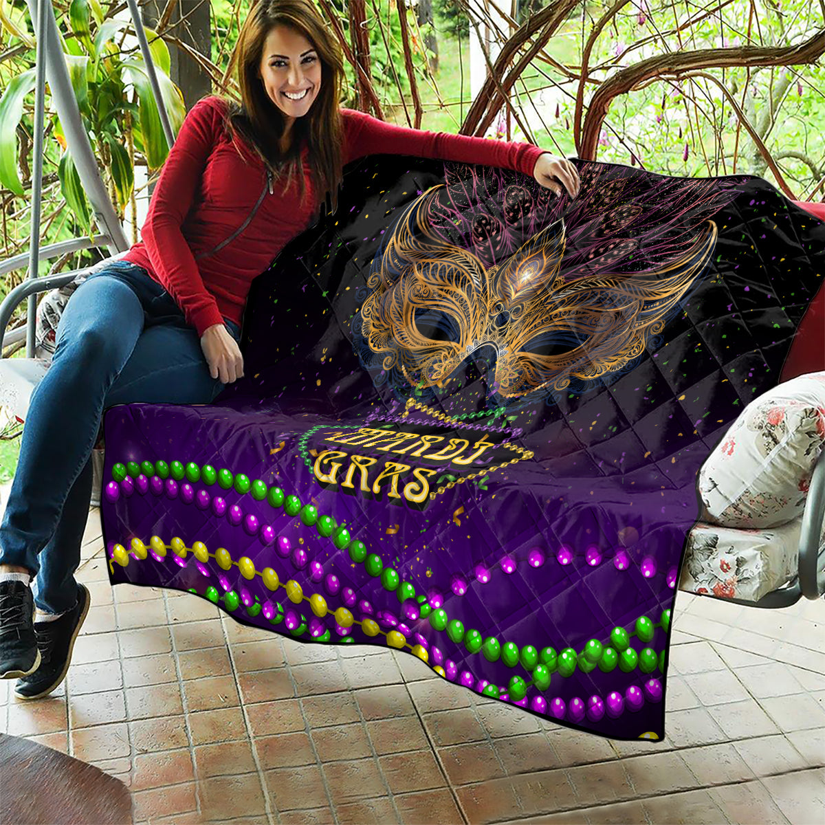 Purple Mardi Gras quilt held up indoors, showing gold bird mask and beaded wave trim