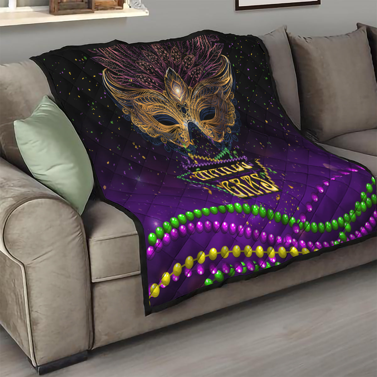 Purple quilt draped on a sofa with gold bird mask artwork and colorful bead wave border