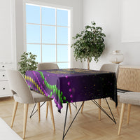 Purple Mardi Gras tablecloth with multicolor beads print, laid across dining table