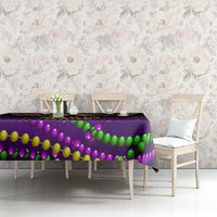 Purple Mardi Gras tablecloth with multicolor bead garland print on long table