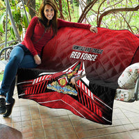 Red quilt spread on patio sofa, black backing and Trinidad and Tobago Red Force emblem