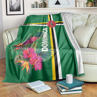 Green blanket with tropical flower print, Dominica text, and striped bands