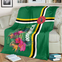 Green blanket with tropical flower print, Dominica text, and bold stripe detail