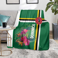 Green Dominica blanket with tropical flowers and striped design on gray chair