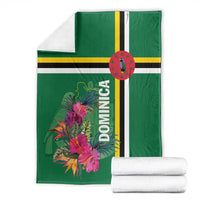 Green Dominica blanket with tropical flower print, shown with folded look and rolled towels
