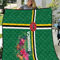 Green quilt held out, with tropical flowers, striped bands, oval emblem, and Dominica text