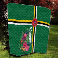 Folded green quilt with tropical floral print, striped bands, and oval emblem with Dominica text