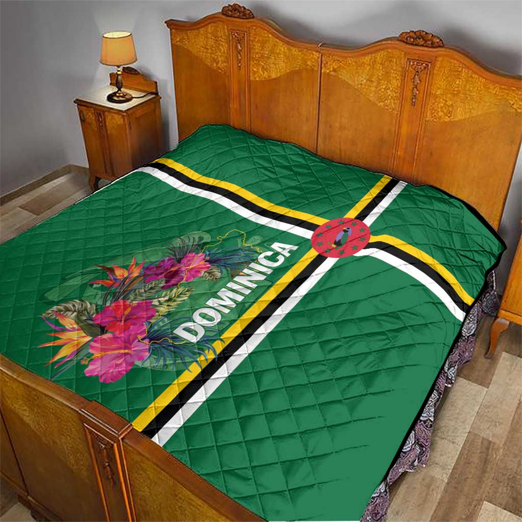 Green quilt on bed with tropical flower print, striped bands, and Dominica text panel