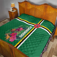 Green quilt on bed with tropical flower print, striped bands, and Dominica text panel