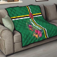 Green quilt on sofa with tropical flowers, striped bands, and oval emblem with Dominica text