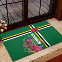 Green rubber doormat with tropical flowers, “DOMINICA” text, and yellow/black stripe accents
