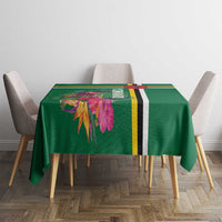 Green tropical floral tablecloth with yellow, black stripe border on small table.