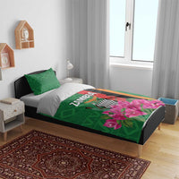 Green bedding set on bed with pink bougainvillea graphic and matching green pillowcases