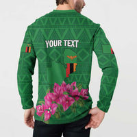 Green button-front sweatshirt, back print with 'YOUR TEXT' and pink blossoms over map graphic