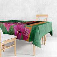 Green floral tablecloth draped over a rectangular table with purple flower print