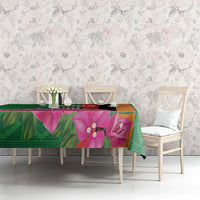 Green tablecloth featuring large pink-purple orchid flowers across the tabletop