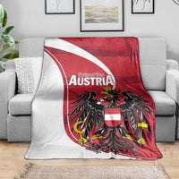 Austria National Day blanket spread on gray sofa, red shield and black eagle graphic