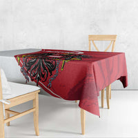 Red tablecloth with black eagle crest centerpiece on dining table