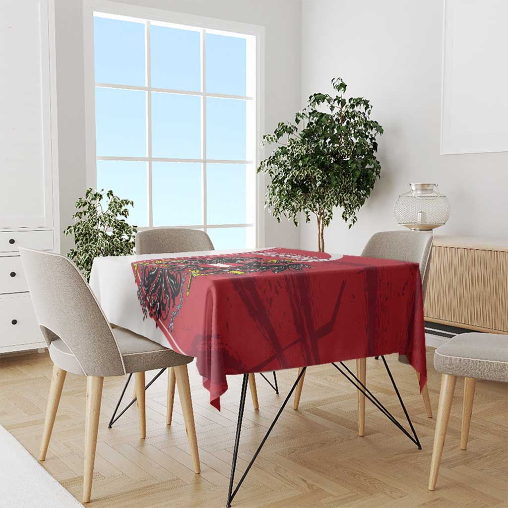 Red tablecloth featuring black eagle and Austria crest on dining set