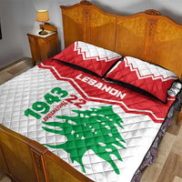 Quilt bed set with white quilt, green cedar print, red accents and two dark-trim pillows