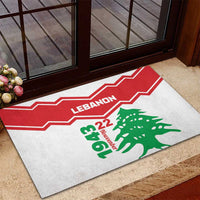 Rubber doormat near doorway with red zigzag stripe and green cedar tree graphic