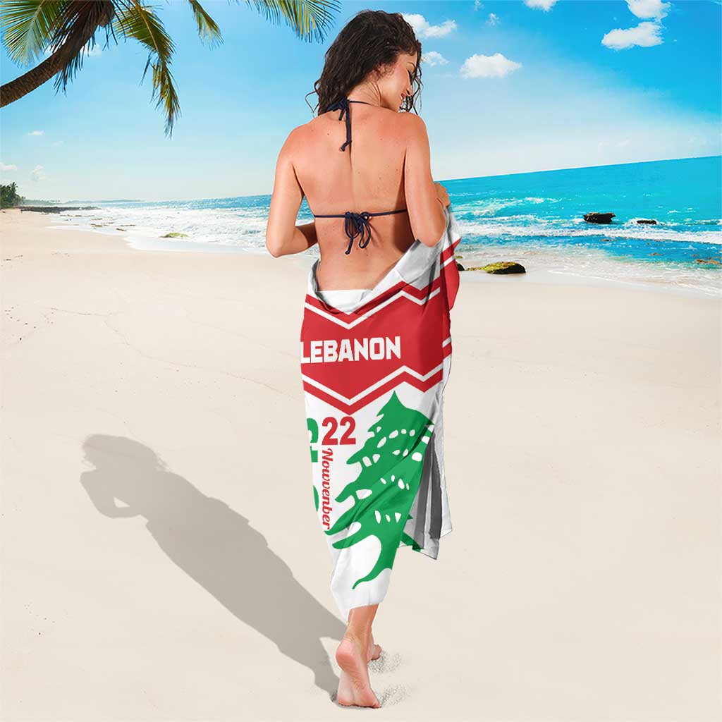 White sarong draped at sides with red Lebanon band and green cedar emblem