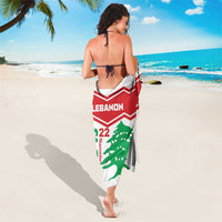 White sarong draped at sides with red Lebanon band and green cedar emblem