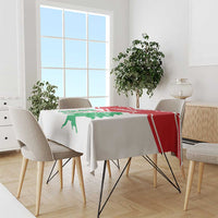 White Lebanon tablecloth with red border and green cedar motif over dining table
