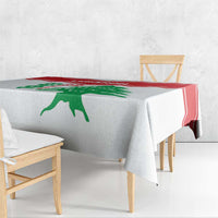 White tablecloth with red stripe border and green cedar motif draped on bench table